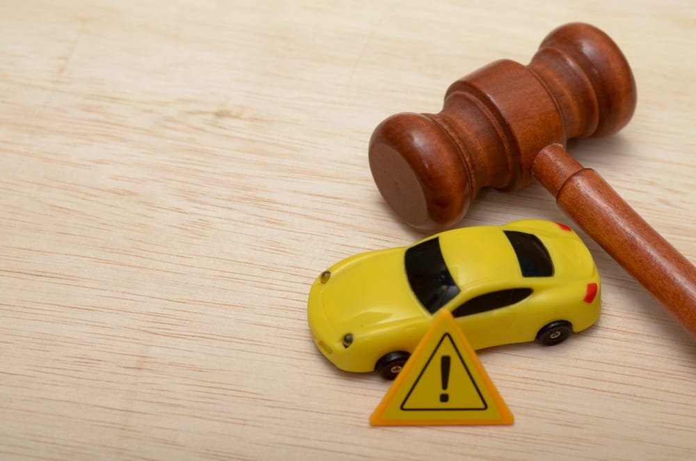 Gavel and toy car representing insurance liability dispute after Fort Lauderdale car accident