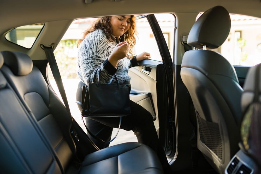 Pasajera entrando a un vehículo de rideshare, momento en que se activa la cobertura más alta del seguro de Uber y Lyft en Florida