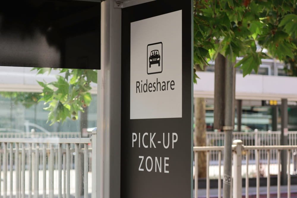 Señal de zona de recogida de rideshare indicando punto de inicio de viajes y activación de cobertura de seguro en Uber y Lyft en Florida