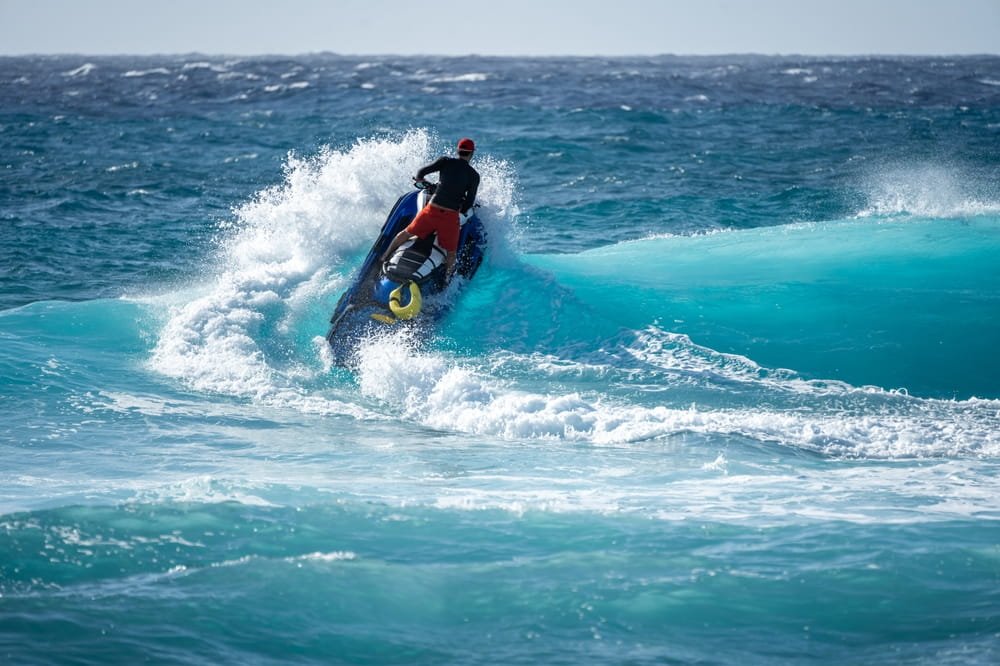 Moto acuática perdiendo el control en olas grandes en Florida, ilustrando el riesgo de lesiones graves en accidentes acuáticos